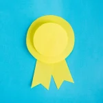 What small and mid-sized businesses need to know about Cybersecurity Maturity Model Certification (CMMC) - yellow paper made ribbon on light blue background.