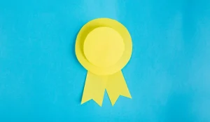 What small and mid-sized businesses need to know about Cybersecurity Maturity Model Certification (CMMC) - yellow paper made ribbon on light blue background.