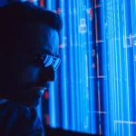 Cyber insurance renewal: will your claim actually be covered in an emergency? - A man in sunglasses intently studies a vibrant blue holographic screen, symbolizing digital technology
