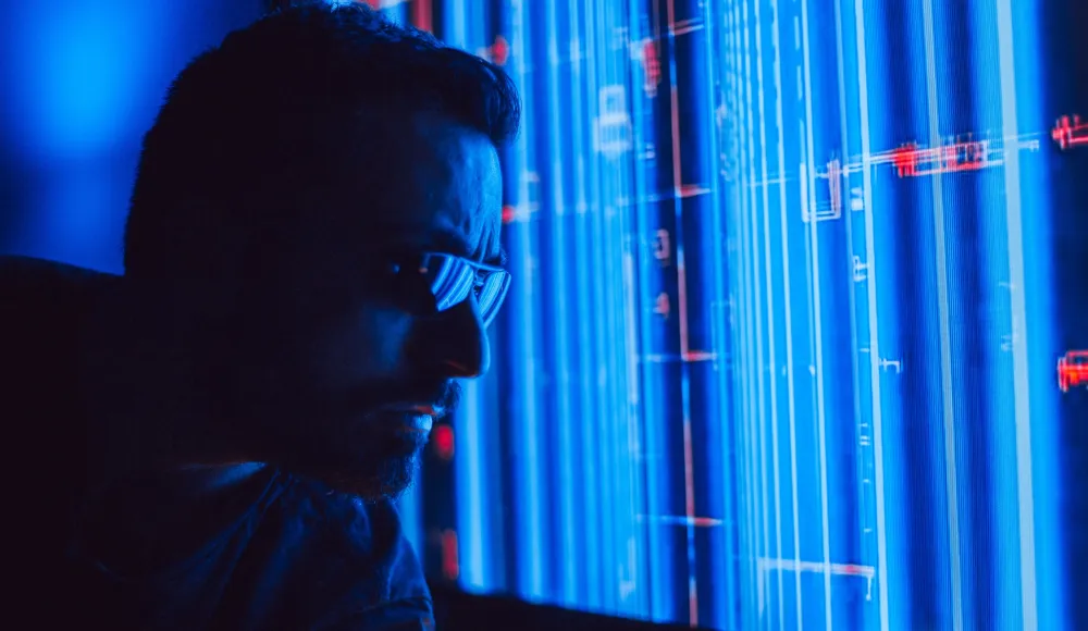 Cyber insurance renewal: will your claim actually be covered in an emergency? - A man in sunglasses intently studies a vibrant blue holographic screen, symbolizing digital technology